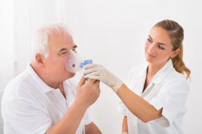 senior man using nebulizer